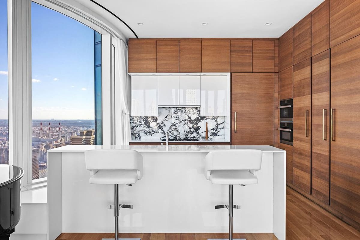 white gloss kitchen island with horizontal wood veneer wall cabinetry designed by eggersmann residence in 252 east 57th st of nyc