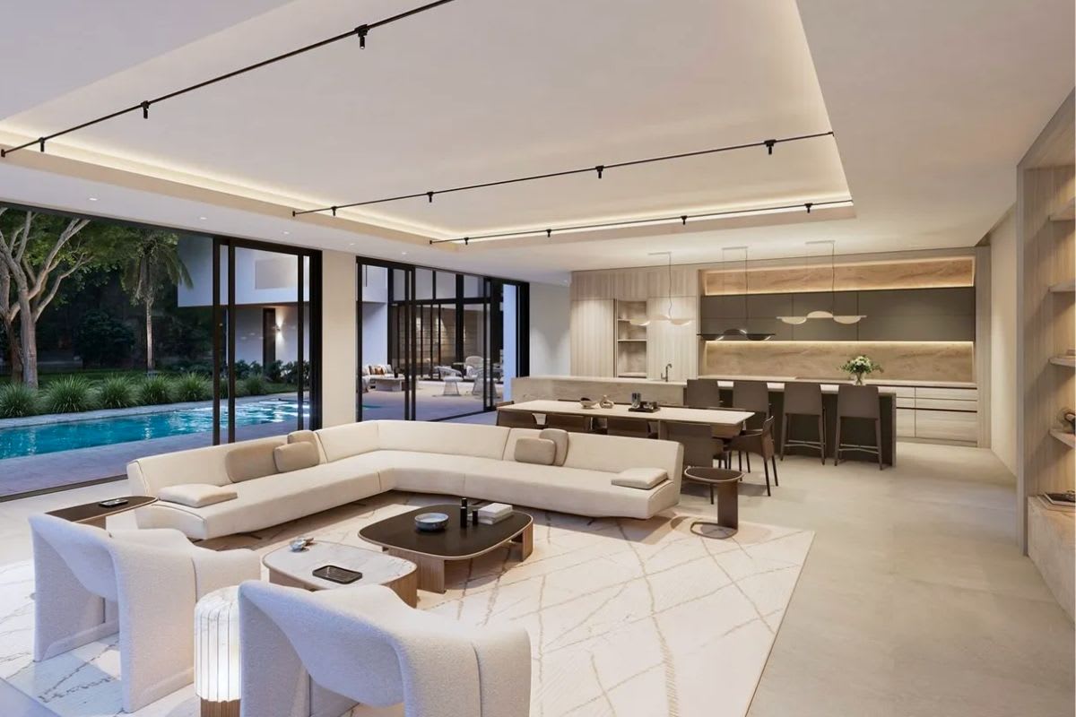 view from the living room of a modern kitchen with a light warm palette designed by ggersmann for a pinecrest florida home
