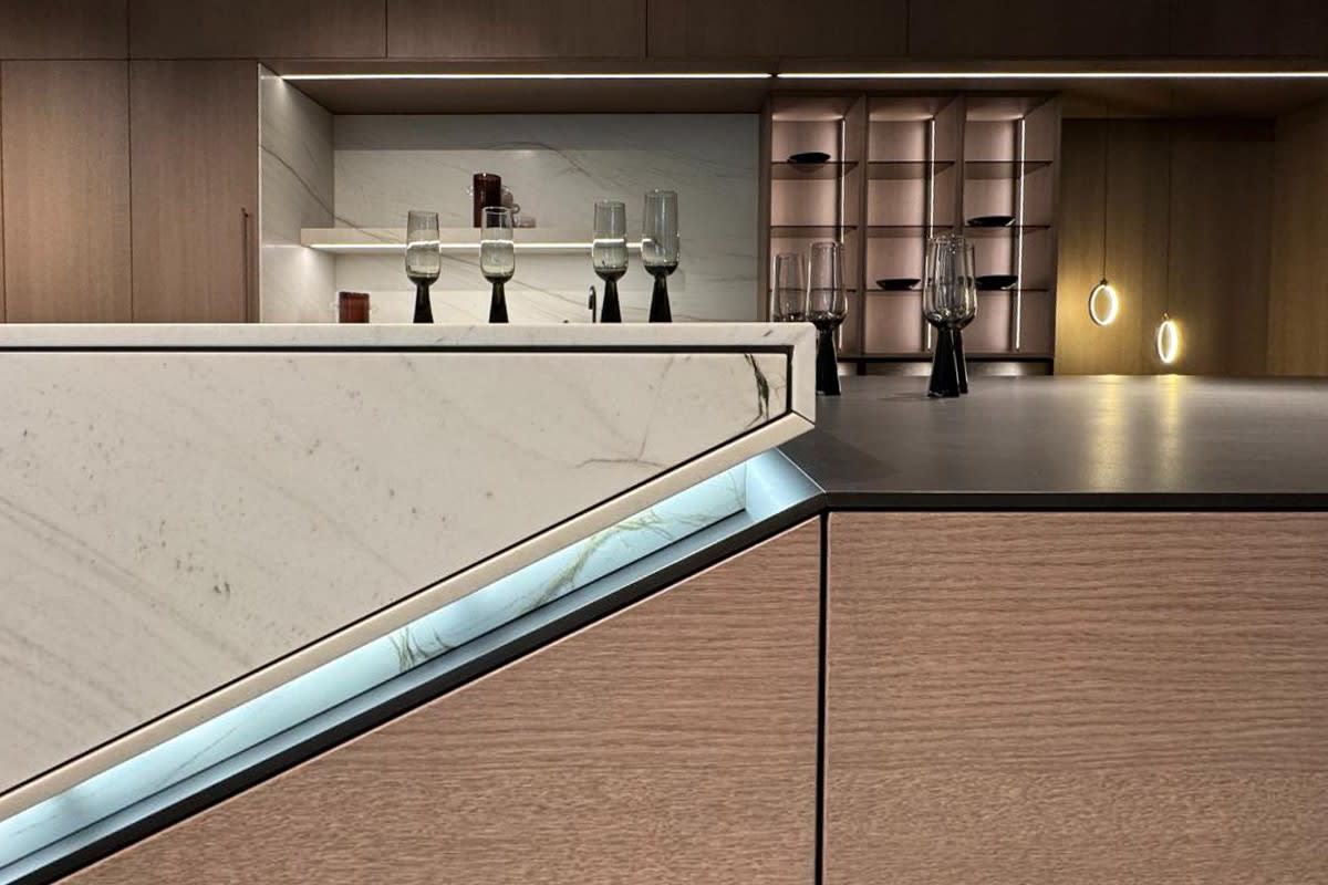 led lighting accents the join of the stone and wood veneer ends of a skywalk kitchen island presented at eggersmann house fair 2025