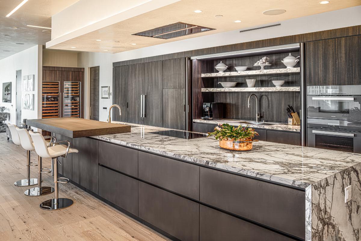 eggersmann-designed concealed kitchen pocket doors open in a residence of the belfiore high rise in houston tx