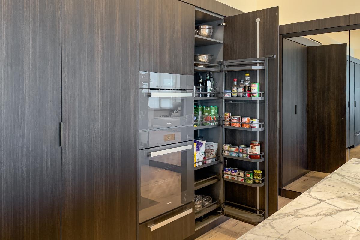 custom food and cookware storage in an eggersmann-designed concealed kitchen in a residence of the belfiore high rise in houston tx