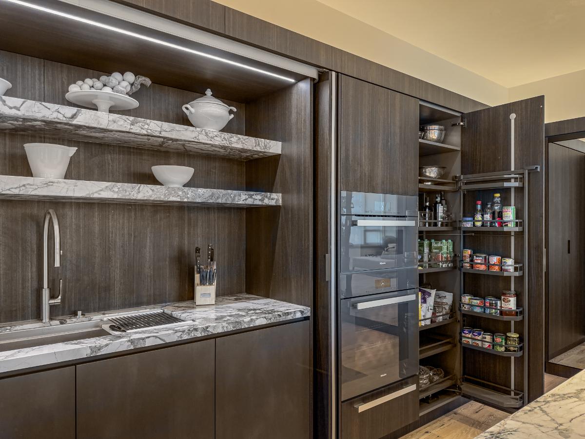 luxury appliances and custom food and cookware storage in an eggersmann-designed concealed kitchen in a residence of the belfiore high rise in houston tx