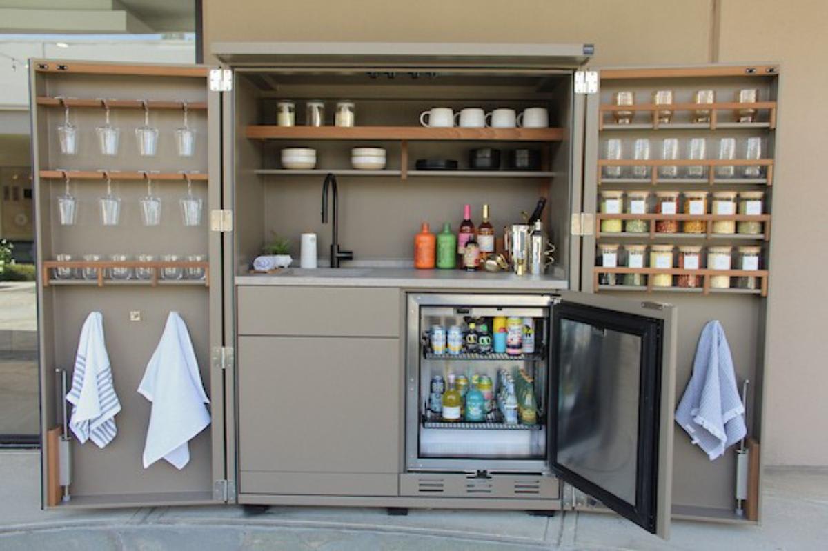 cubic kitchen in a cupboard with a light taupe interior and integrated refrigerator and sink