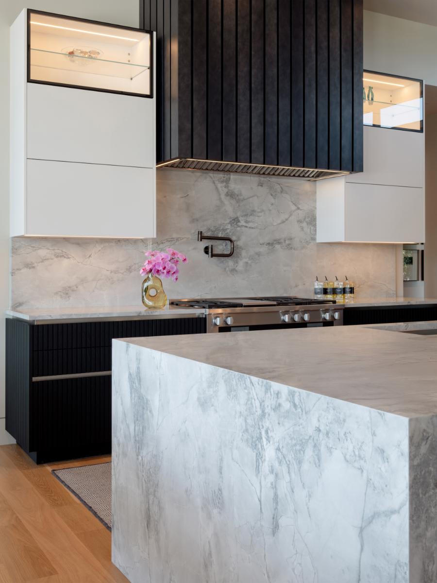 illuminated glance glass display features atop upper cabinets of a kitchen designed by eggersmann for a david lewis home