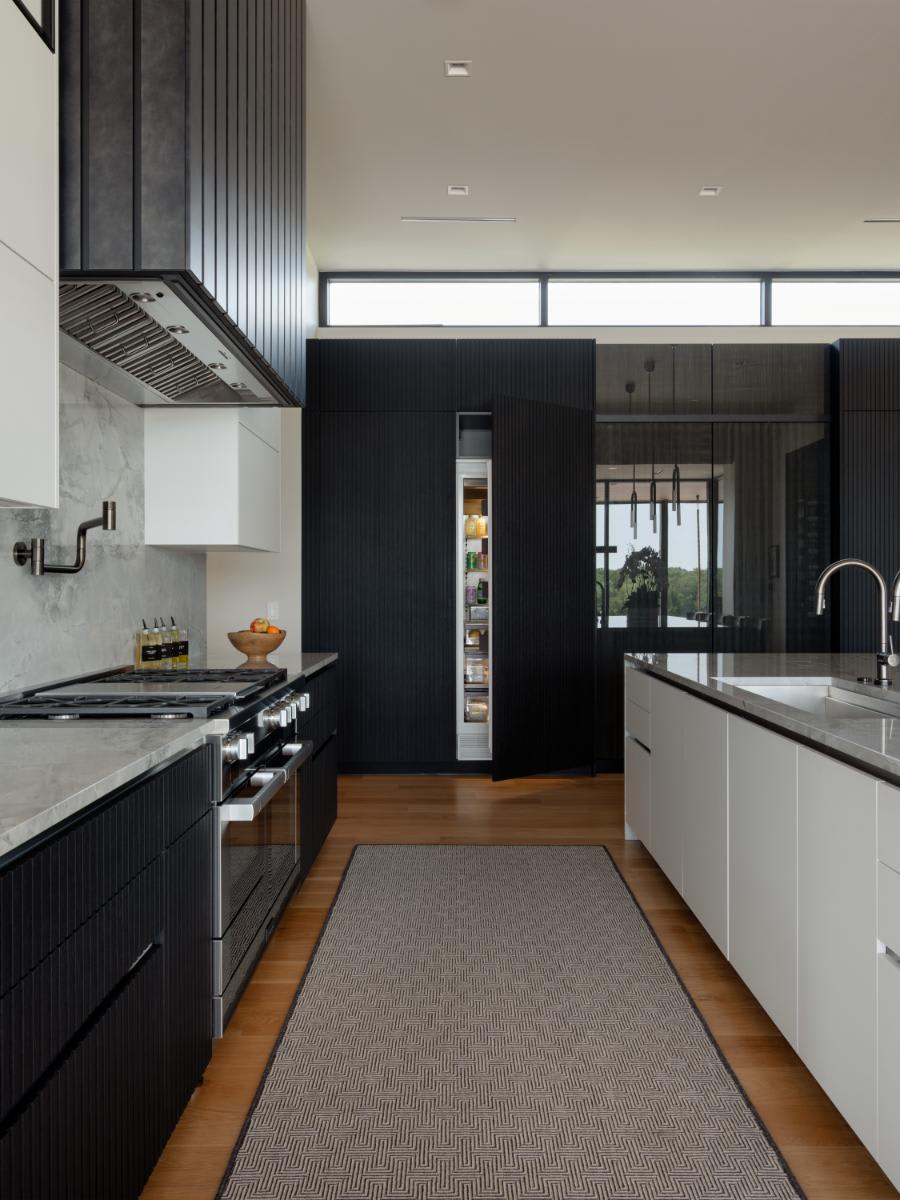 galley of a kitchen with integrated refrigerator door ajar designed by eggersmann for a david lewis home