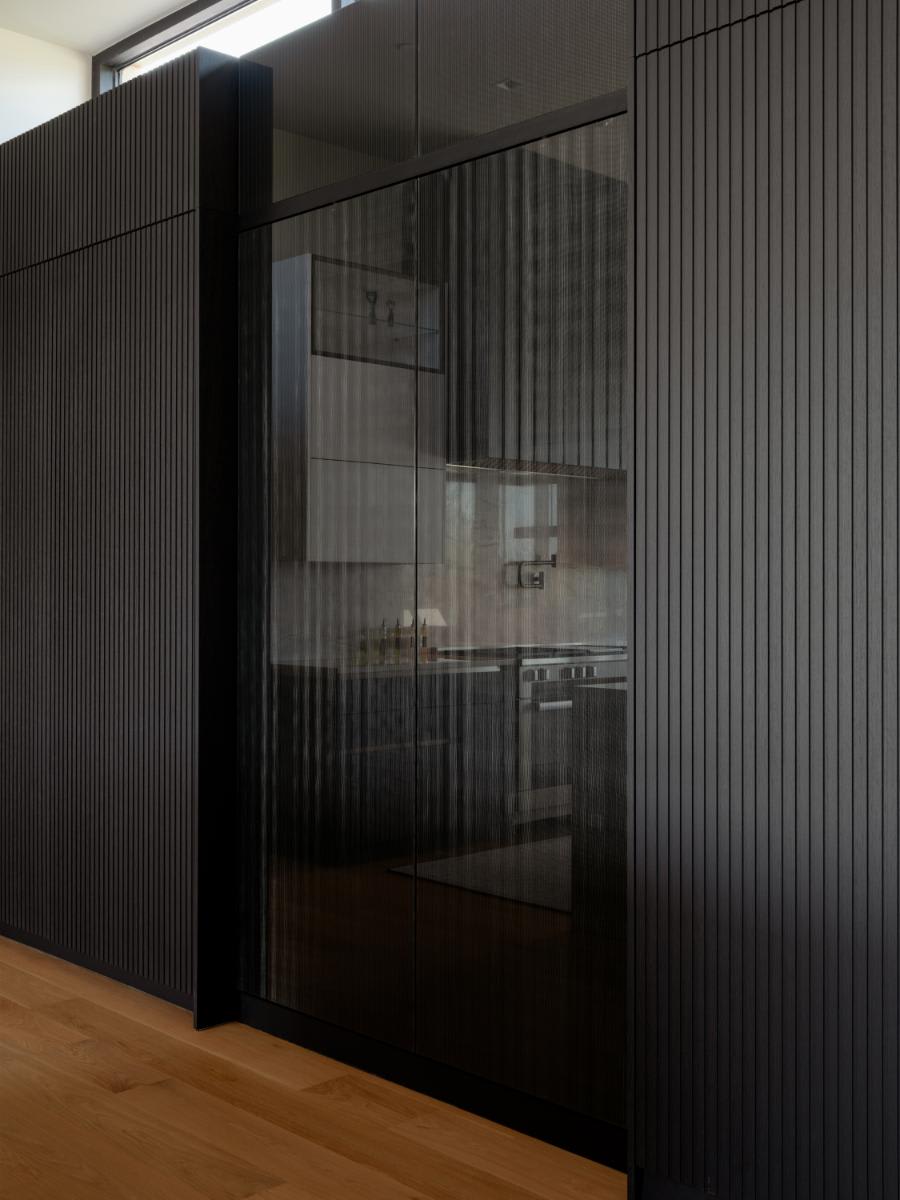 work's turnstile pantries in their closed position to show the interlink bronze fronts in the middle of a lausanne wood veneer cabinet wall