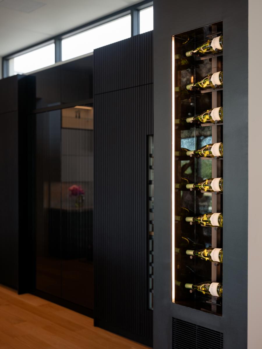 glass-front illuminated wine fridge in a kitchen designed by eggersmann for a david lewis home