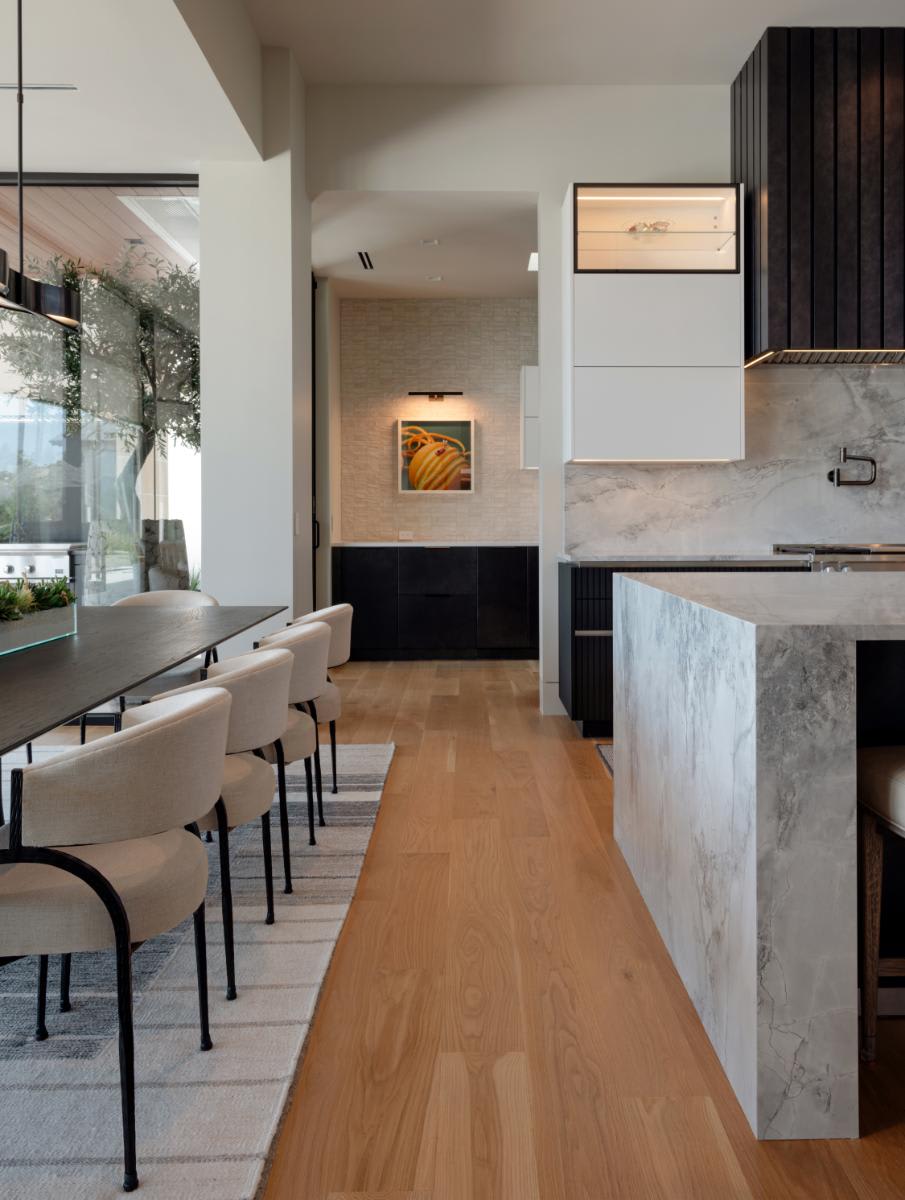 walkway between the dining room and kitchen capturing a glance glass display feature in an upper cabinet designed by eggersmann for a david lewis home