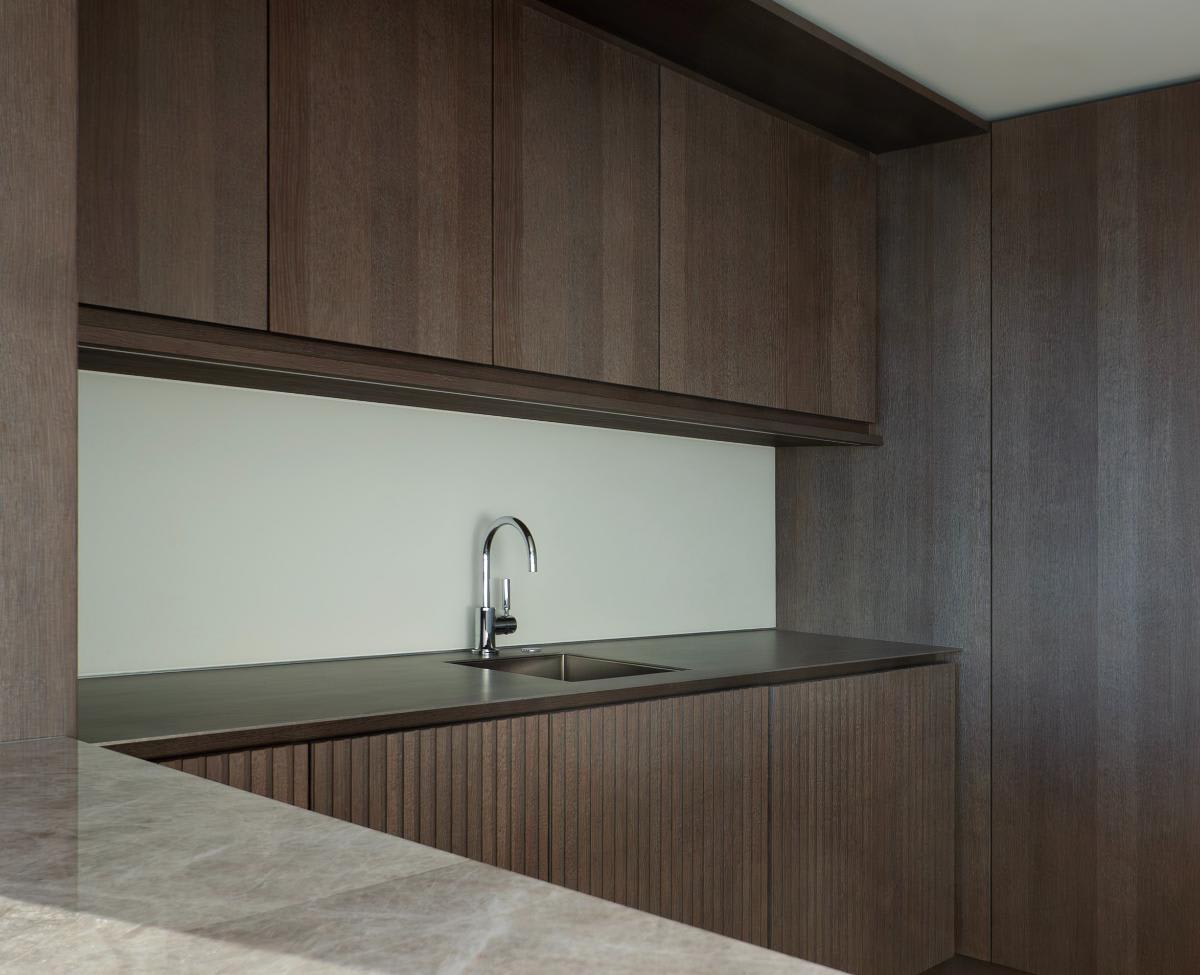 bar sink and sleek handleless wood veneer cabinetry in a wet bar of a modernist kitchen in chicago