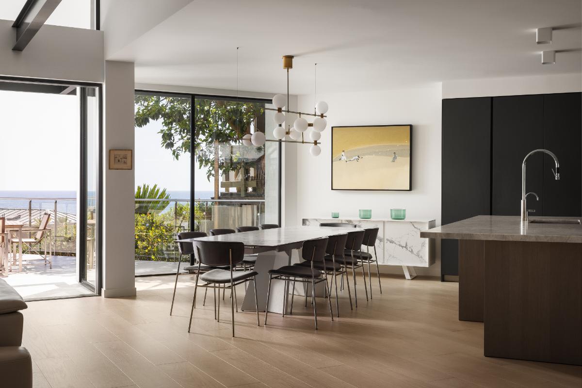 adjacent dining space for a light-filled dark wood veneer finished kitchen in a lagunitas home in laguna beach