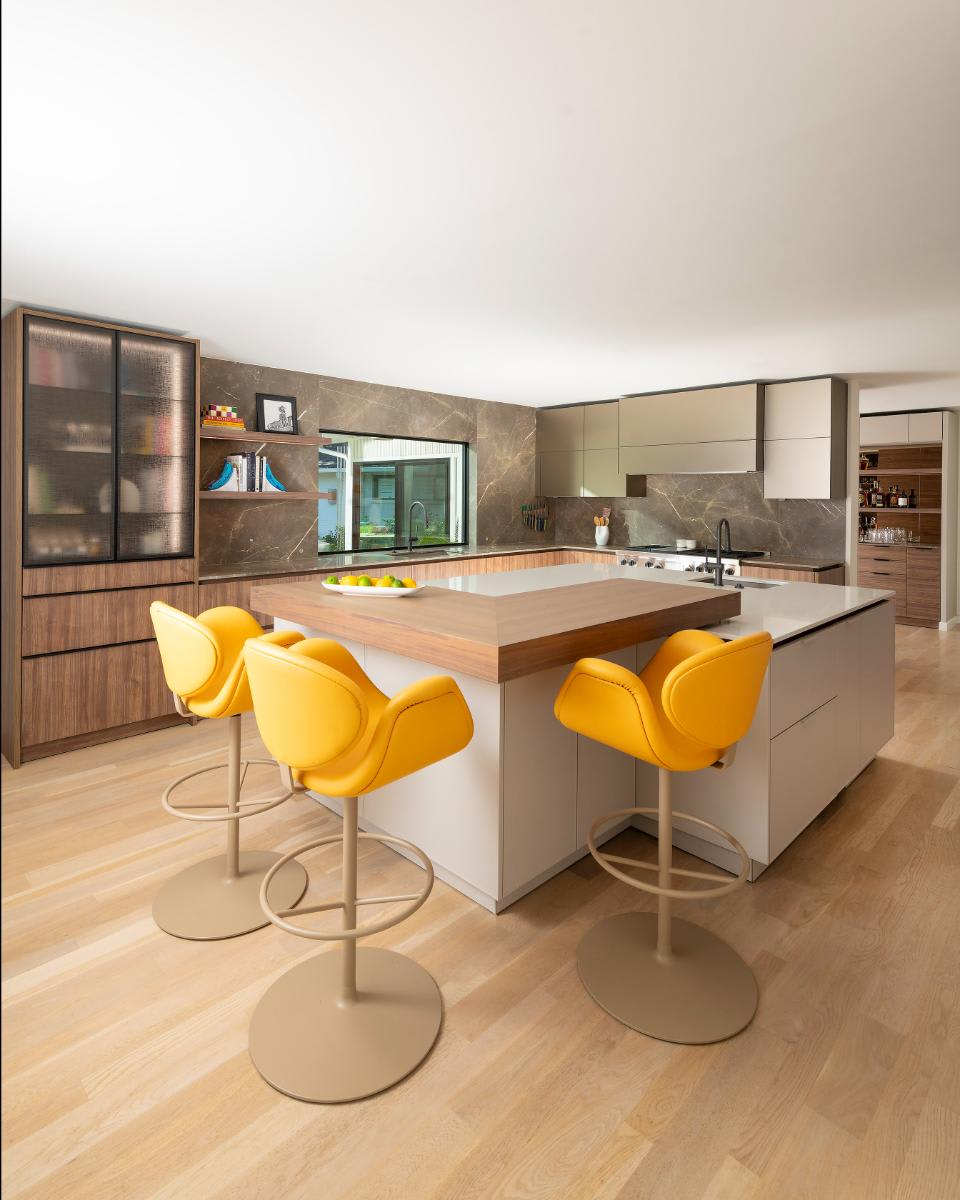 mid-century inspired kitchen designed by eggersmann for a Preston Hollow renovation featuring a white kitchen island with spekva wood bartop and vertical wood veneer cabinetry
