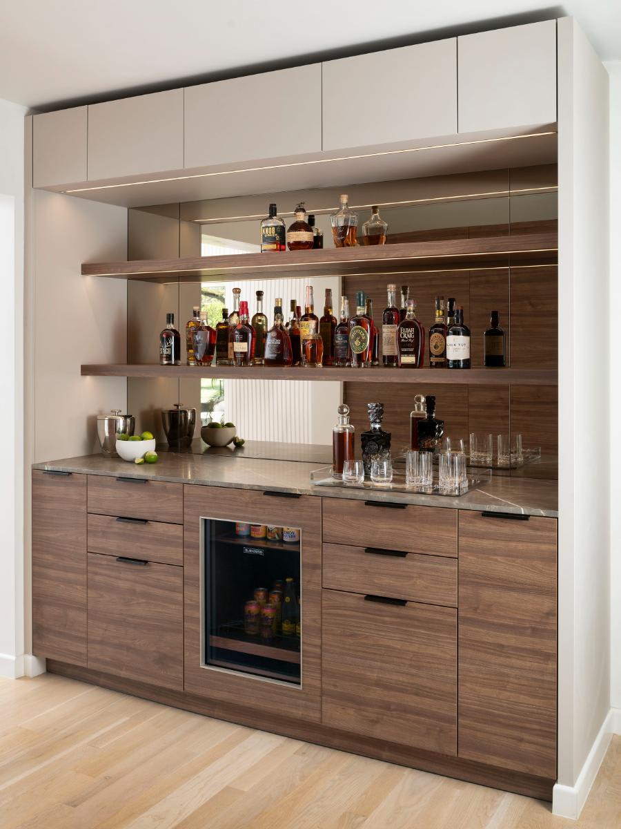 butler's bar in warm wood veneer with mirrored backsplash to reflect light designed by eggersmann dallas for a Preston Hollow kitchen renovation