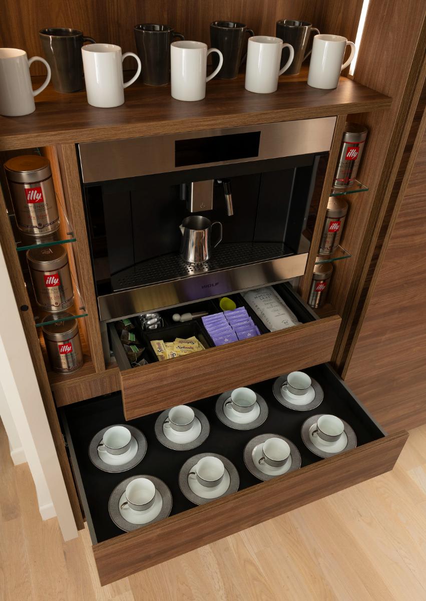 closeup of organized drawers of a coffee bar in a horizontally grained wood veneer wall-mounted cabinet designed by eggersmann for a Preston Hollow kitchen renovation