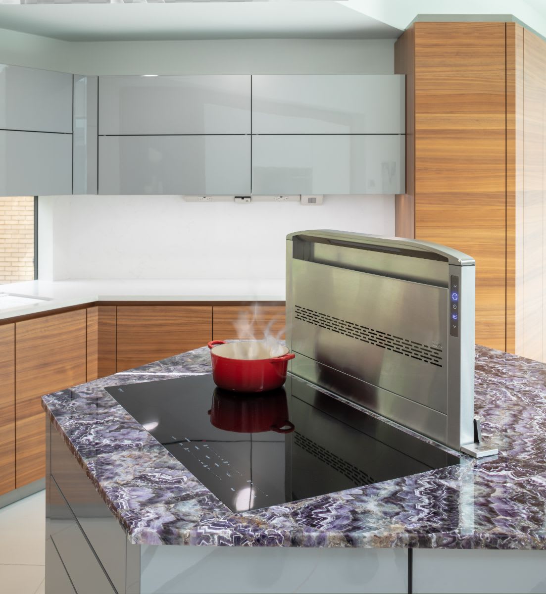 very peri colored stone island with inset cooktop and pop up steam vent