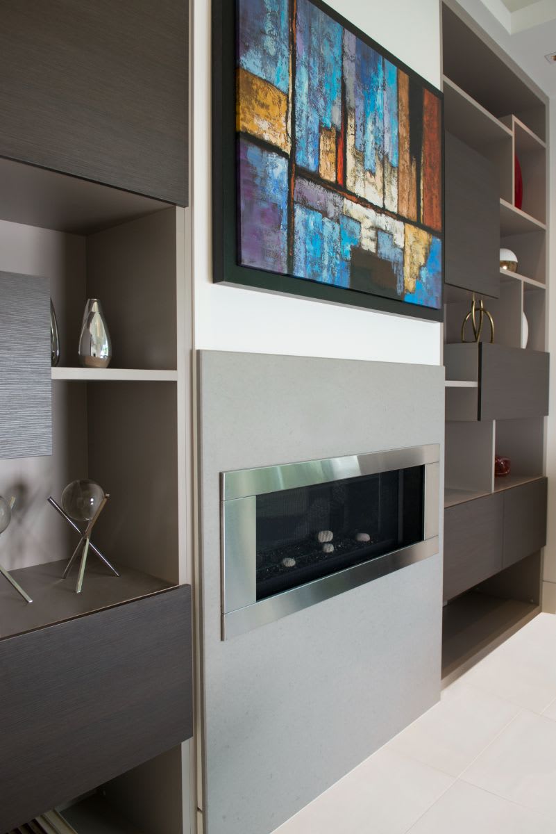 closeup of a sleek chrome-framed fireplace by dimplex under artwork