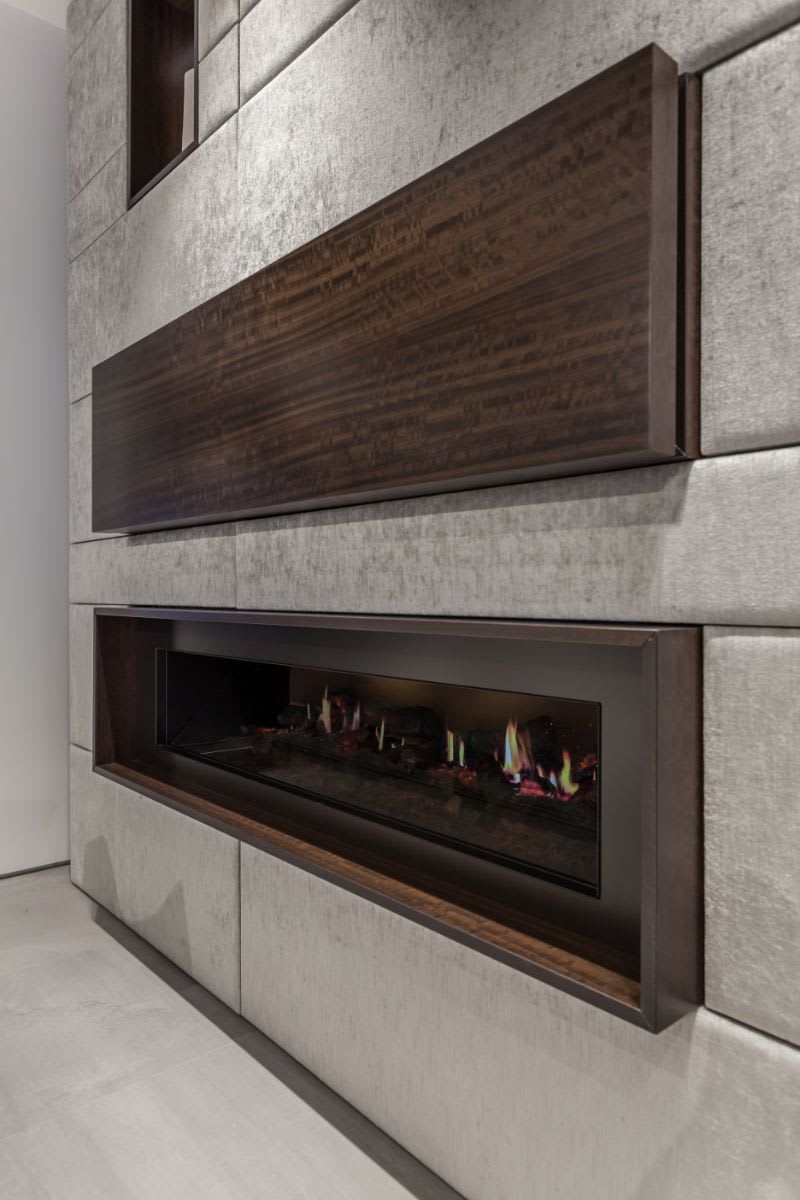 closeup of a closed hidden bar and modern framed fireplace by dimplex in an eggersmann-designed media wall