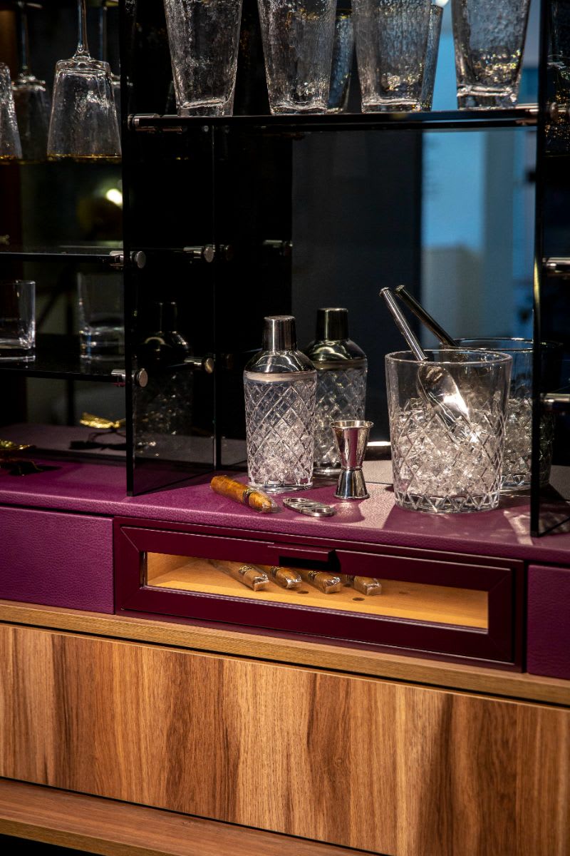 built-in glass-front humidor in a media wall designed by eggersman with schmalenbach cabinetry components