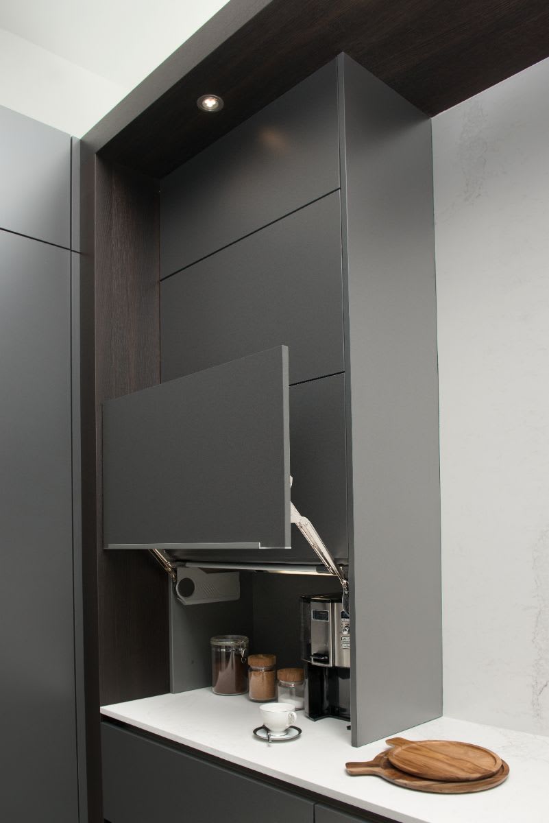 hidden coffee bar tucked behind automated vertical-swing doors designed by eggersmann