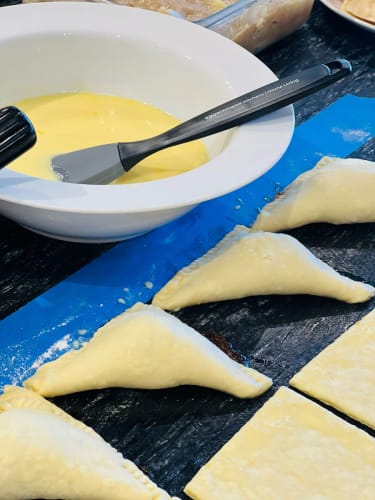 danish pastry dough filled and folded over to prepare them for baking