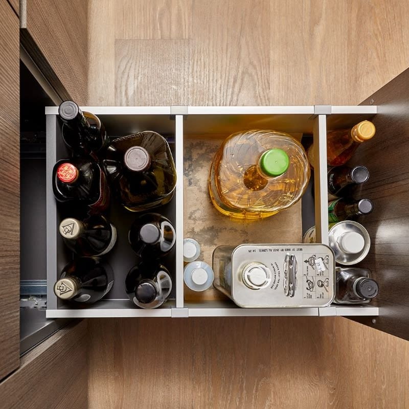 cabinet pullout with built-in boxtec dividers for secure storage of large bottles of cooking oil and other cooking needs