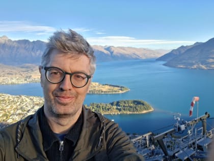 Tom, founder of natif, standing outdoors above Queenstown with lake and mountains behind him