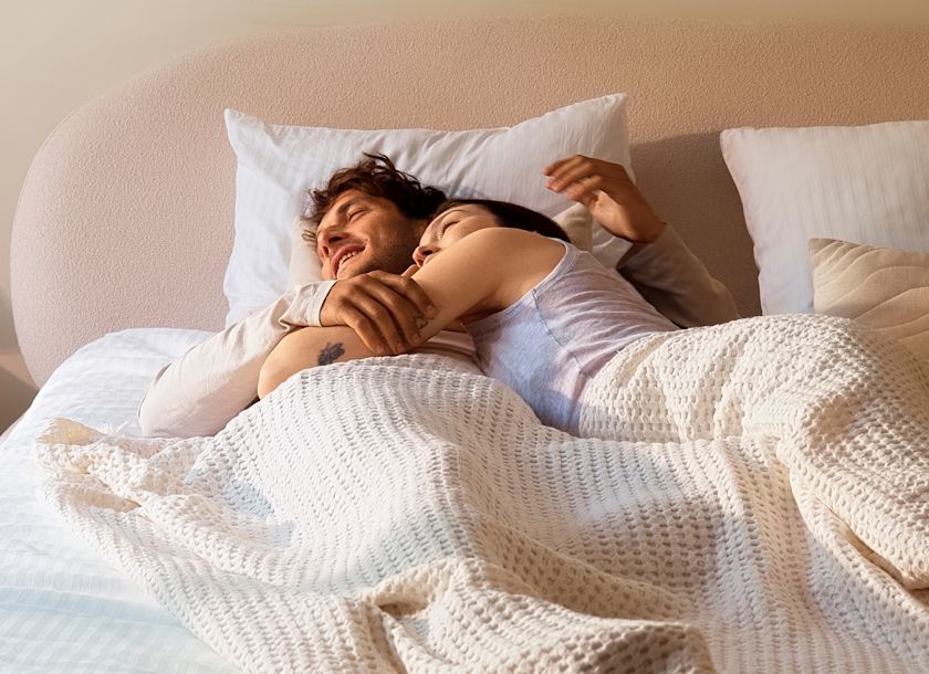 A couple sleeping comfortably together in bed on the Pod