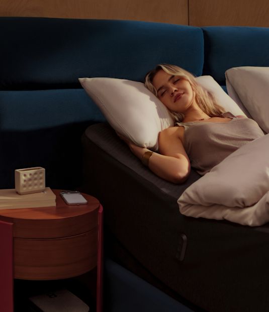 A woman asleep on her side, with a card showing 59 minutes of snoring today against a 7-day average of 1 hour 4 minutes