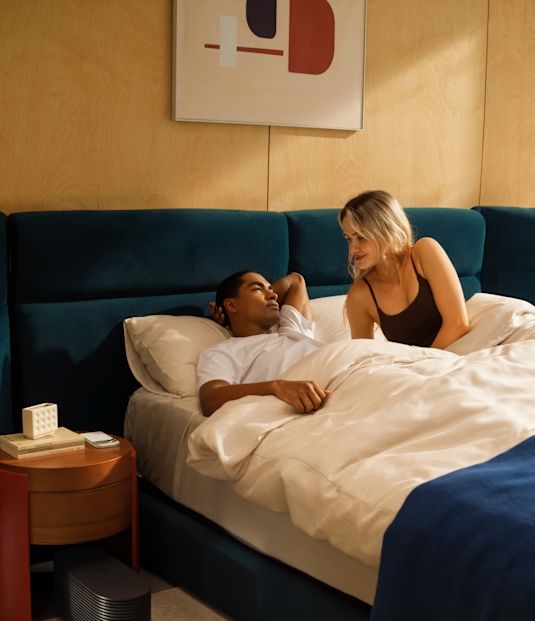 A couple in bed, one awake, with a card reading “Cardio disturbances 0.5%” and a note that high disturbances were detected