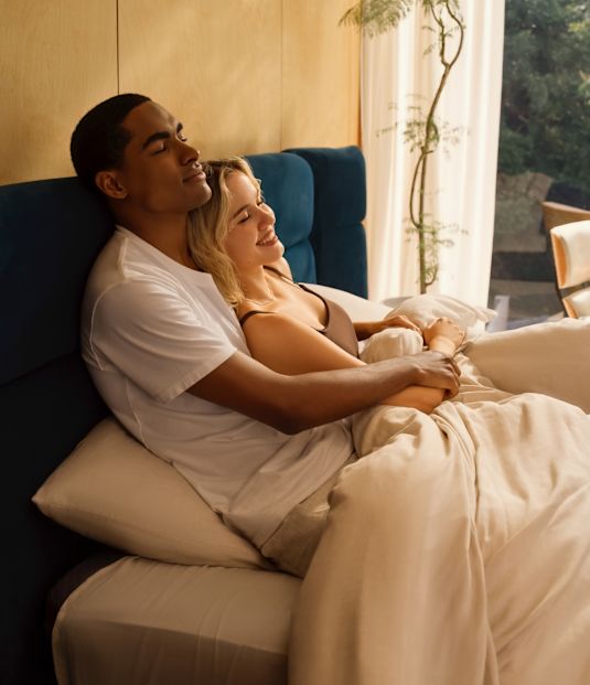 A couple in bed in a sunlit room