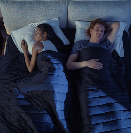 A top-down view of a couple in bed where the left side is cooler and the right side is warmer