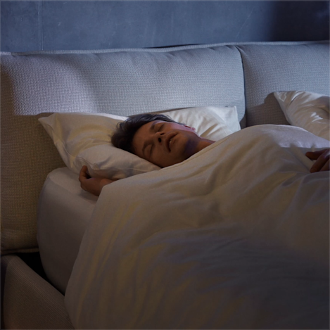 A view of a person alseep in bed with the Ultra Base elevating them to prevent snoring