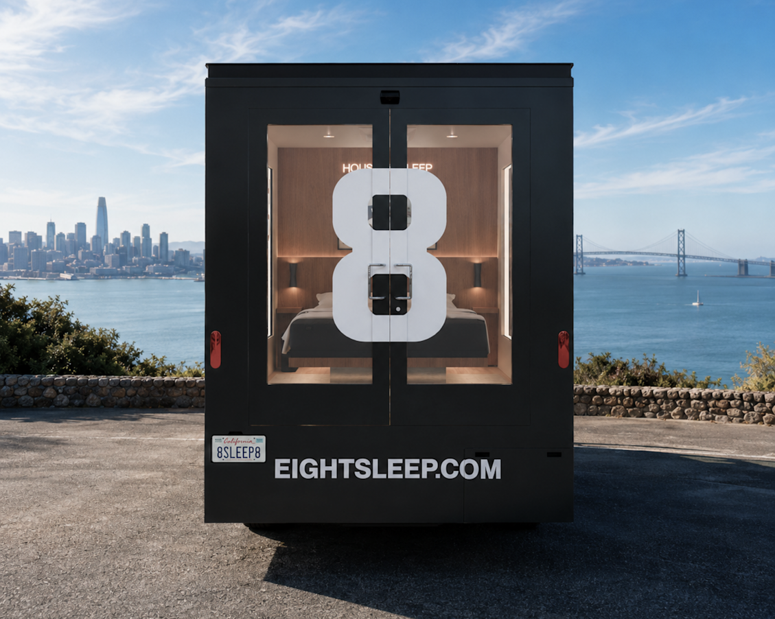 Rear of the House of Sleep truck parked above the San Francisco Bay, the Eight Sleep logo and Pod visible through the doors with the city skyline and Bay Bridge behind