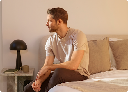 A member sitting on the edge of the bed in early morning light