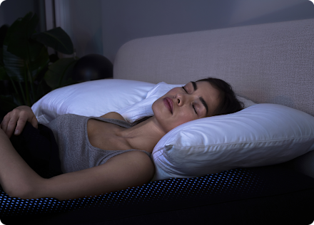 A member asleep on their side in a darkened bedroom