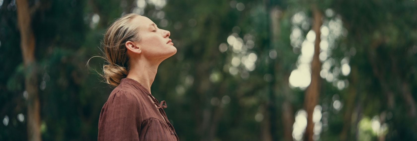 Frau mit geschlossenen Augen vor Waldhintergrund | 4-7-8 Atmung