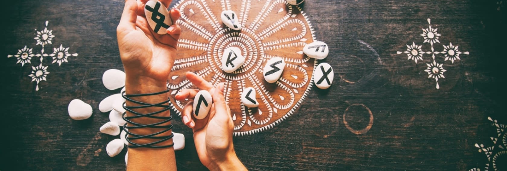 Hände die Runensteine werfen