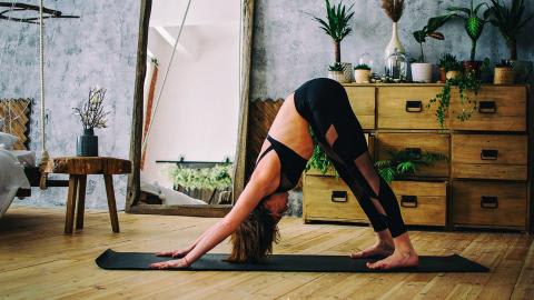 Frau in Yoga Pose Herabschauender Hund