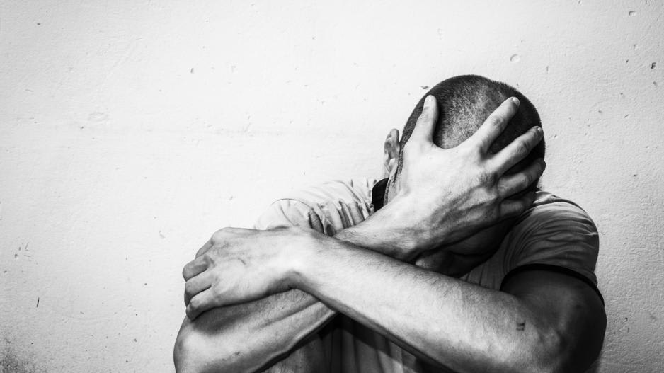 Mann stützt verzweifelt den Kopf in die Hände weil er süchtig ist Mann stützt verzweifelt den Kopf in die Hände weil er süchtig ist