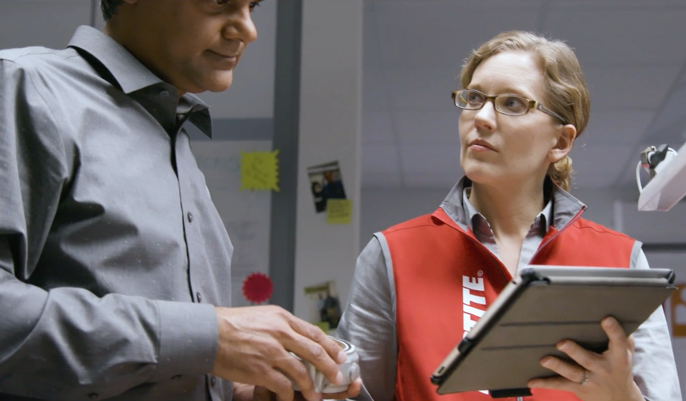 Woman from Loctite showing iPad to man.