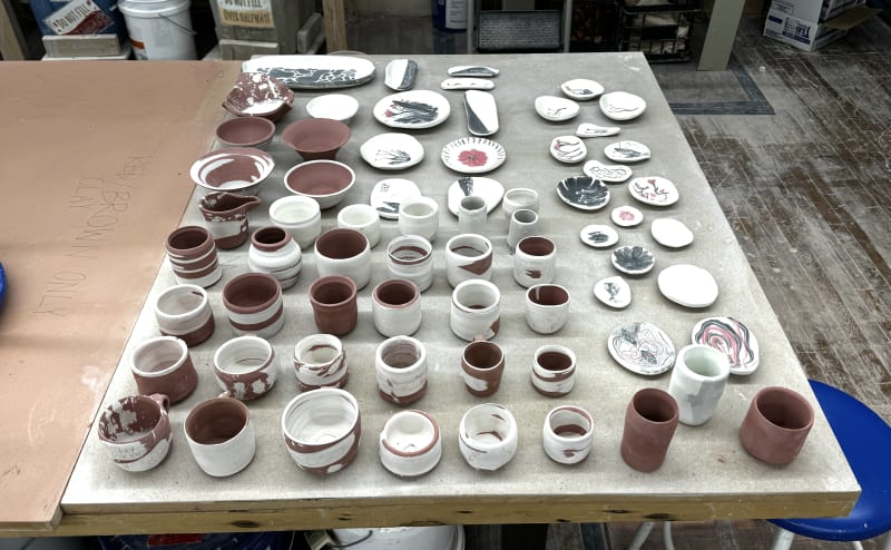 My collection of greenware bowls, cups, and plates ready to be fired