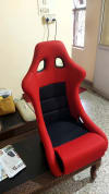 Red and Black Fiber Racing Bucket Seat on a Wooden table.