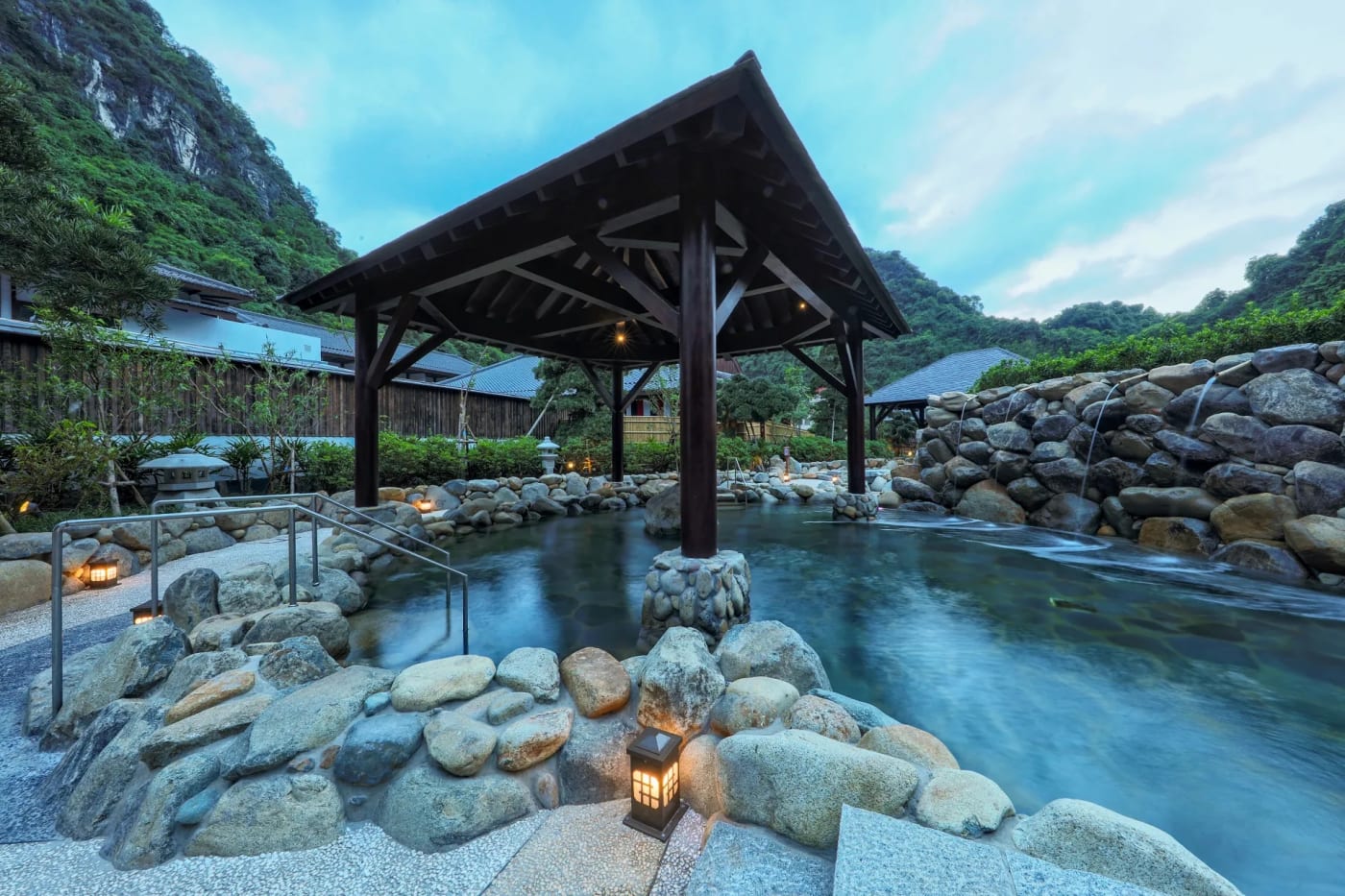 Le bassin d’onsen extérieur du Hilton Quang Hanh Onsen Resort, pavillon en bois et rochers