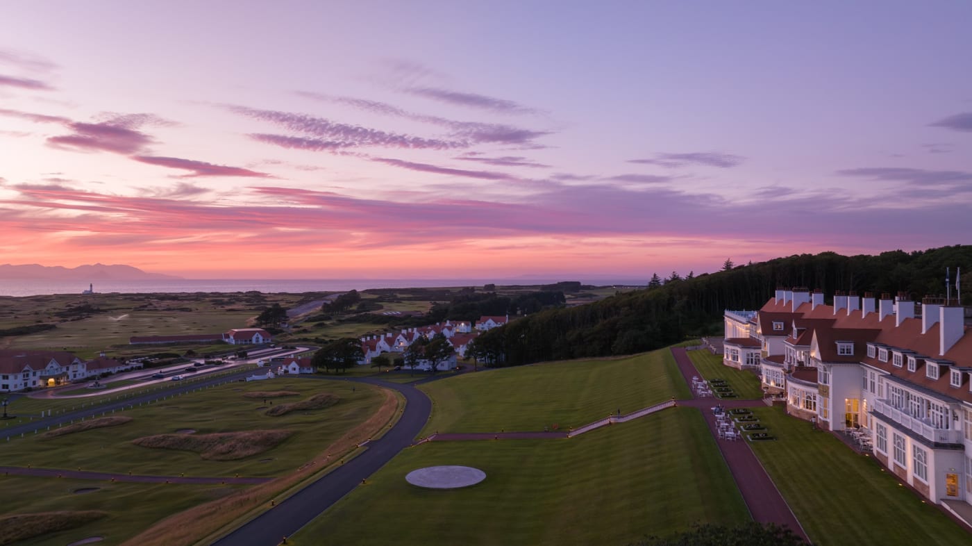 La façade blanche de l'hôtel Trump Turnberry dominant les parcours au crépuscule