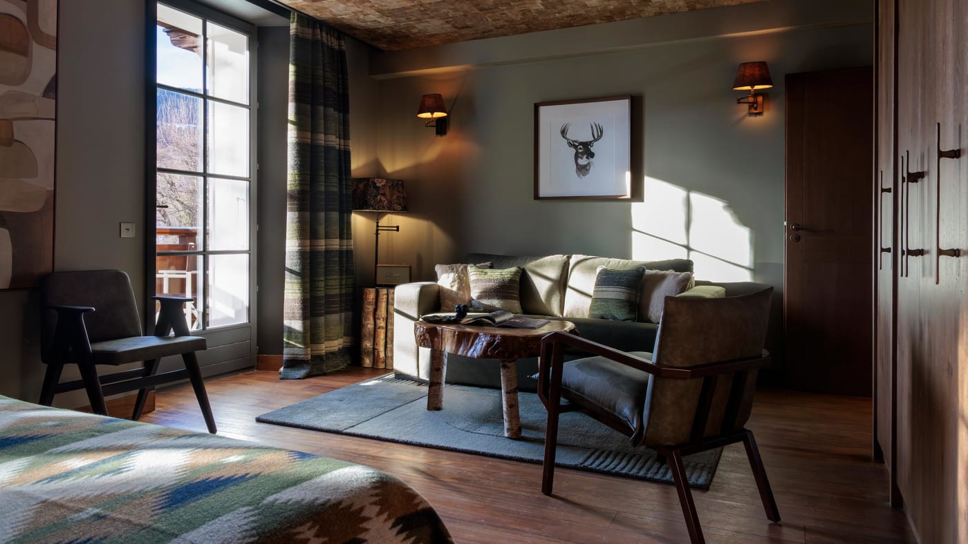 Sitting room of a suite at the Lodge Park in Megève, sofa, armchairs and tartan curtains