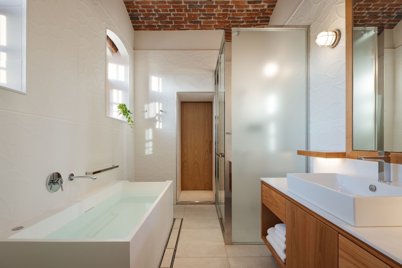 Weißes Badezimmer mit Badewanne in einer Suite des Hotels Hoshinoya Nara Prison