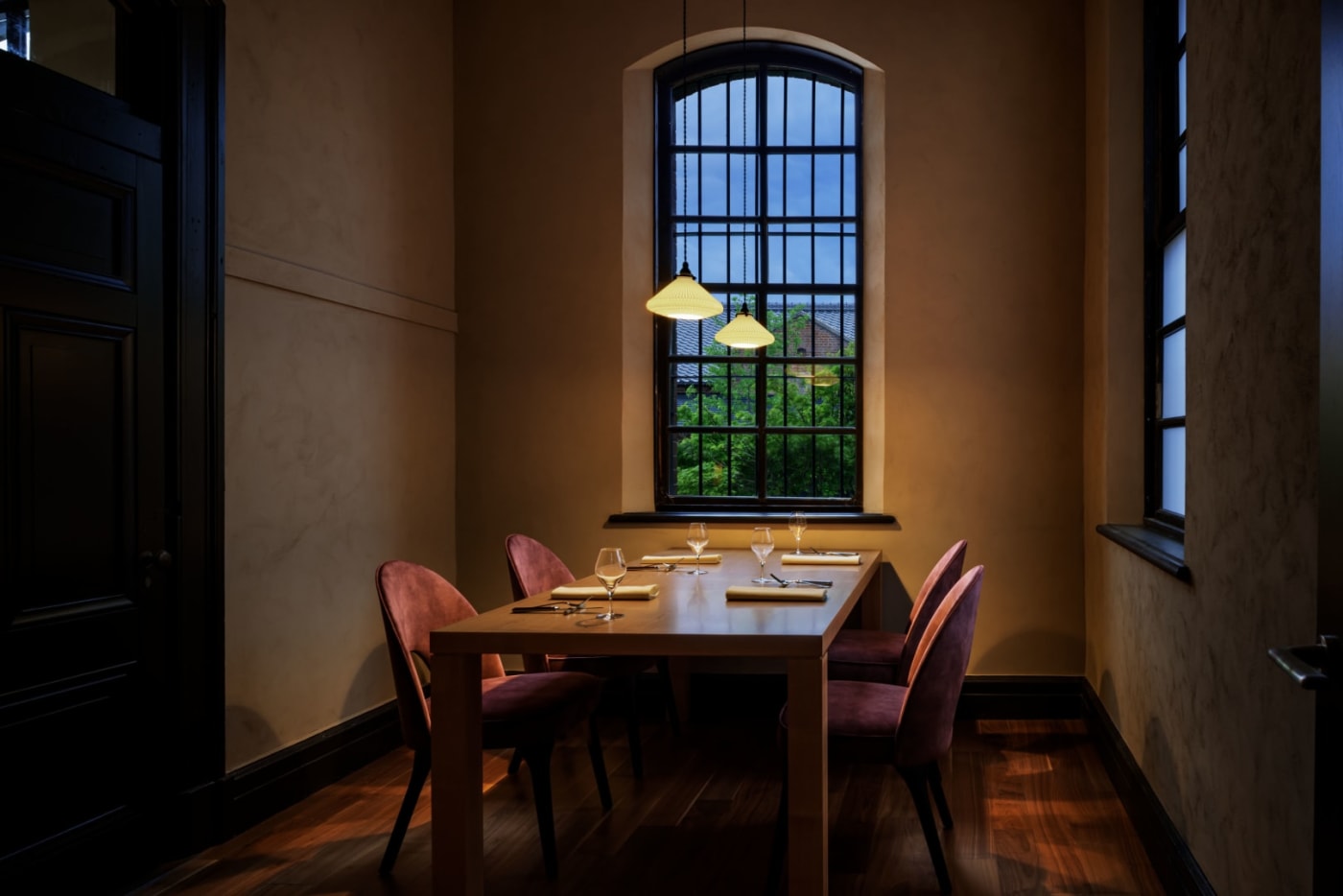 Gedeckter Tisch vor einem hohen Rundbogenfenster im Speisesaal des Hotels Hoshinoya Nara Prison