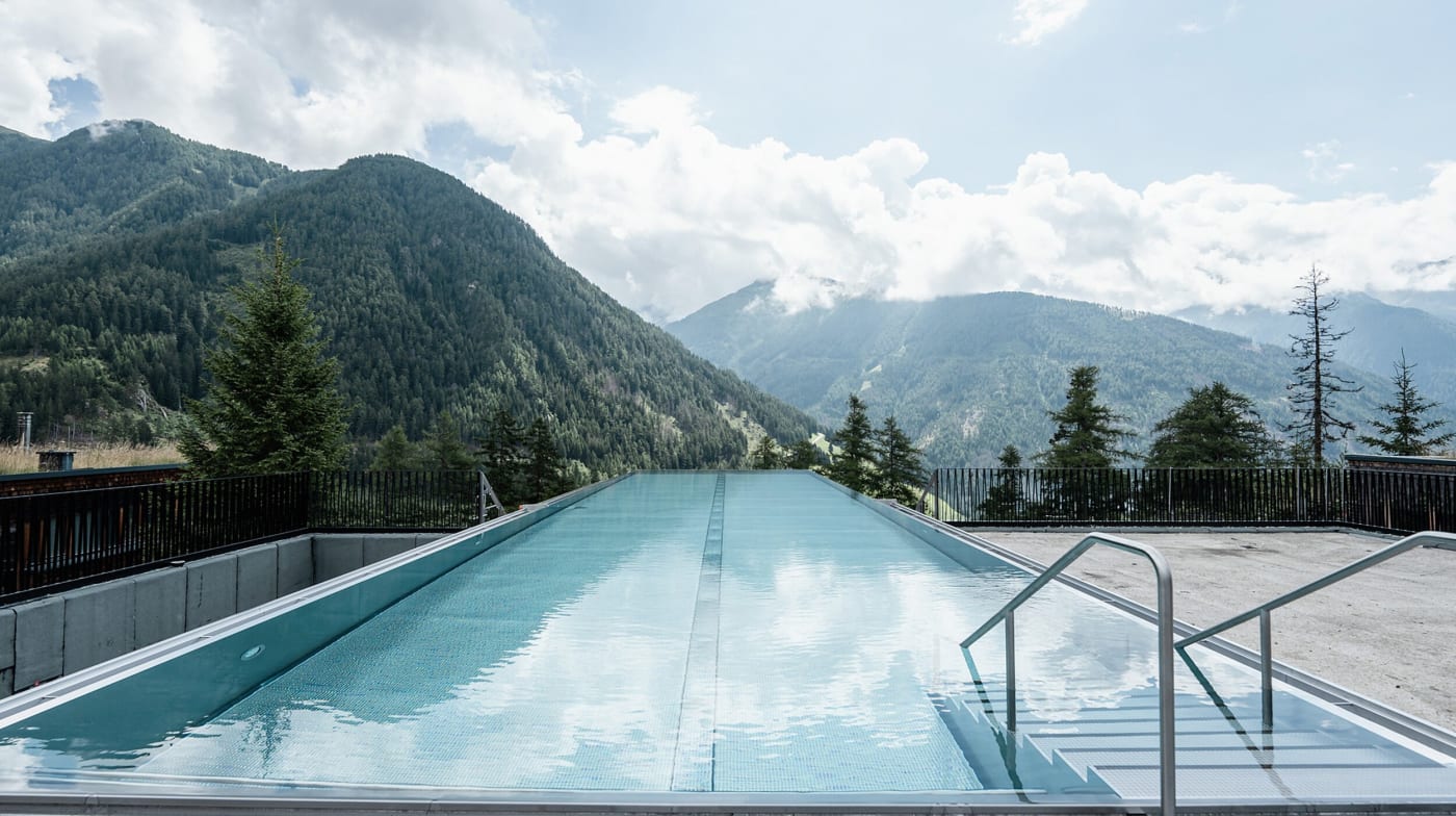 A piscina de borda infinita do Gradonna Mountain Resort diante das montanhas de Kals am Großglockner