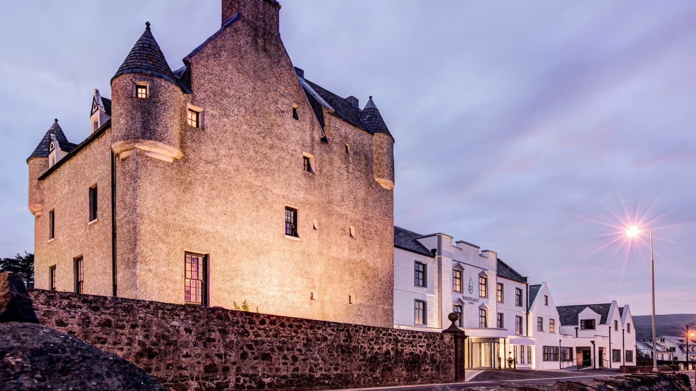 El castillo de Ballygally y sus torreones iluminados al atardecer, en la costa de Antrim