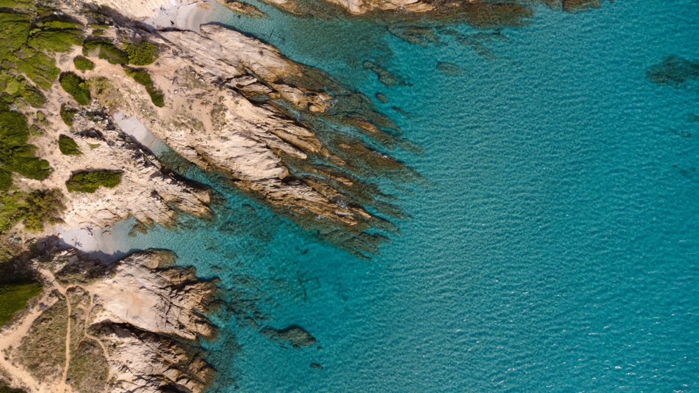 Vue aérienne de rochers et d'eaux turquoise sur la côte, visuel du Mas Bellevue Saint-Tropez