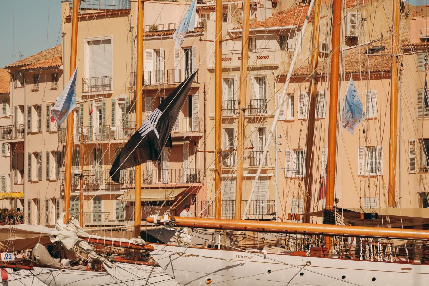 Voiliers classiques amarrés devant les façades ocre du port de Saint-Tropez